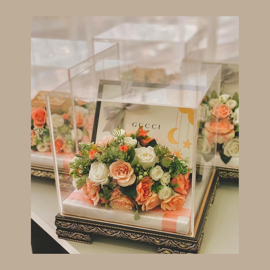 Trousseau trays under clear acrylic lids, each wrapped gift crowned with roses