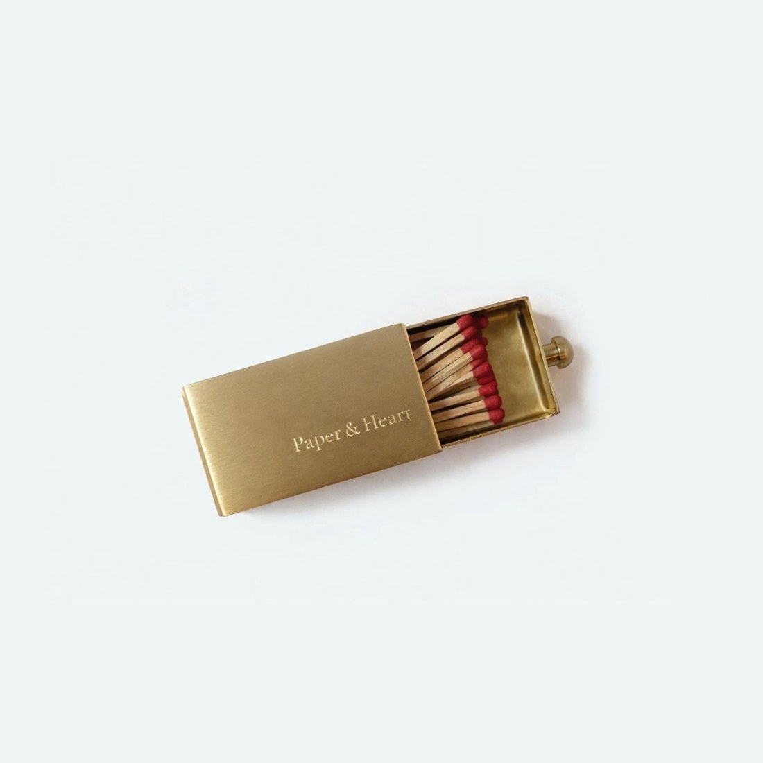 A gold matchbox stamped with the studio name